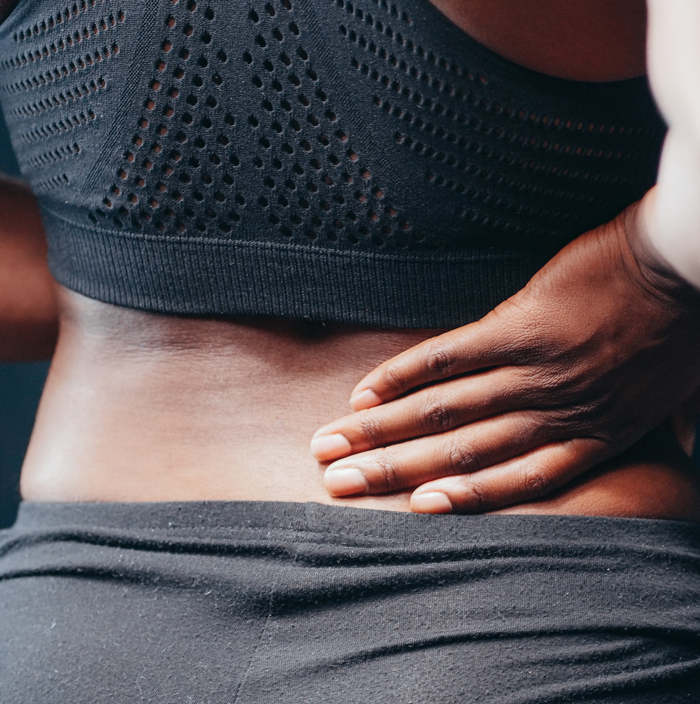 person holding their lower back